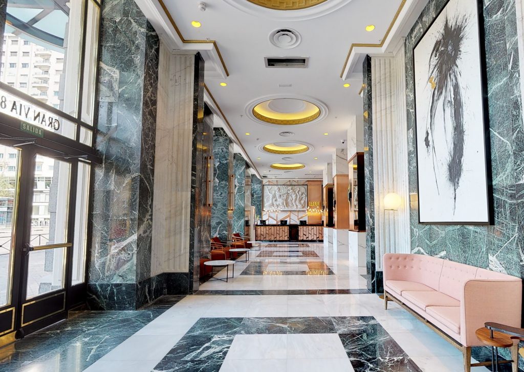 pasillo hall central suelo de marmol decoracion elegante sillones naranjas belta frajumar hotel riu madrid
